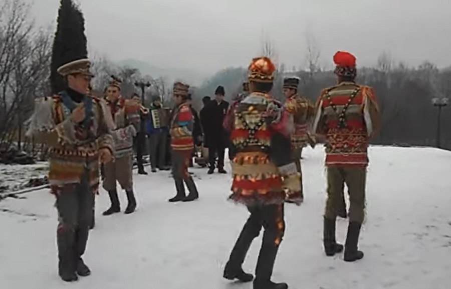 Bungherii, junii din Bucovina, îmbrăcați în uniforme militare austriece, joacă în cerc și strigă în joc la trecerea dintre ani